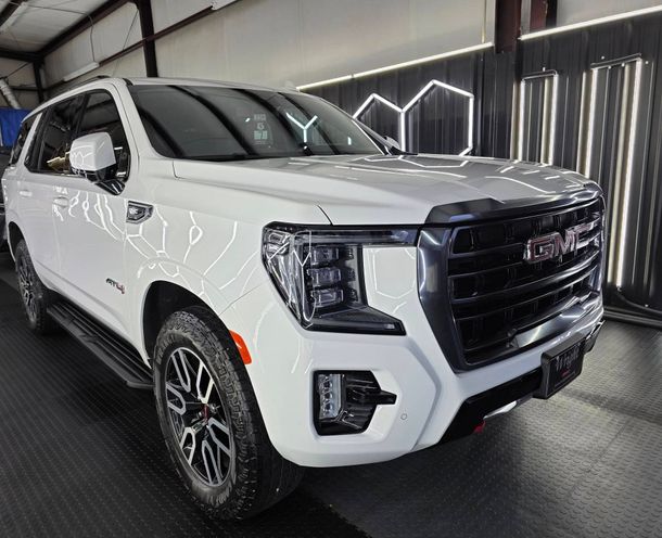 White tesla driving down snowy road