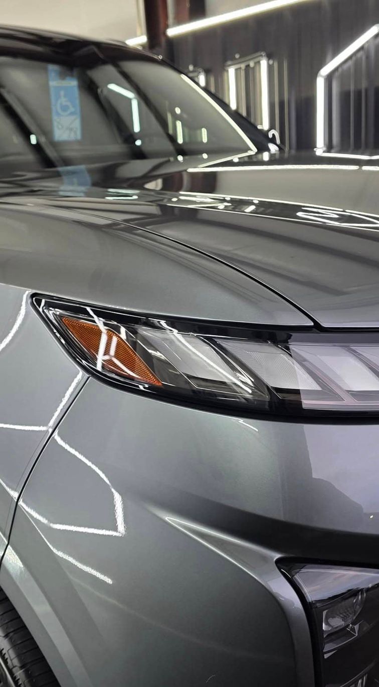 Wet tesla parked at the side of a road